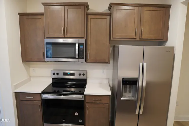 a kitchen with stainless steel appliances a stove microwave and refrigerator