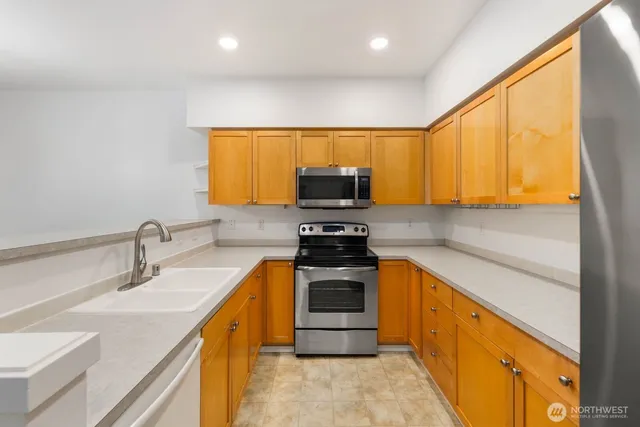 a kitchen with stainless steel appliances a stove a sink and a microwave