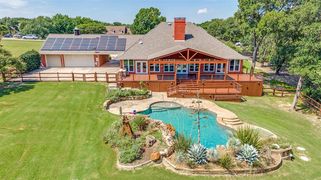 9 Country Ridge Road Melissa, TX 75454 - Photo 5 of 37 Great view of what the back of the home offers! Lage driveway area to turn cars and park. Garage doors face the back as well as the solar panels. THe huge porch and shaded area. The custom pool, waterfall and amazing landscaping!!