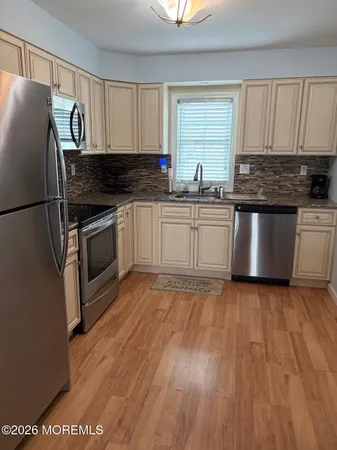 a kitchen with granite countertop a refrigerator and a stove top oven