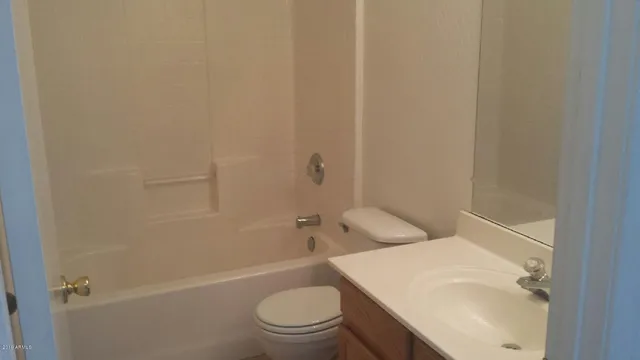 a white toilet sitting next to a bath tub
