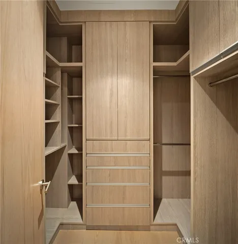 a view of walk in closet with empty racks