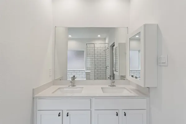 a bathroom with double sink and a mirror