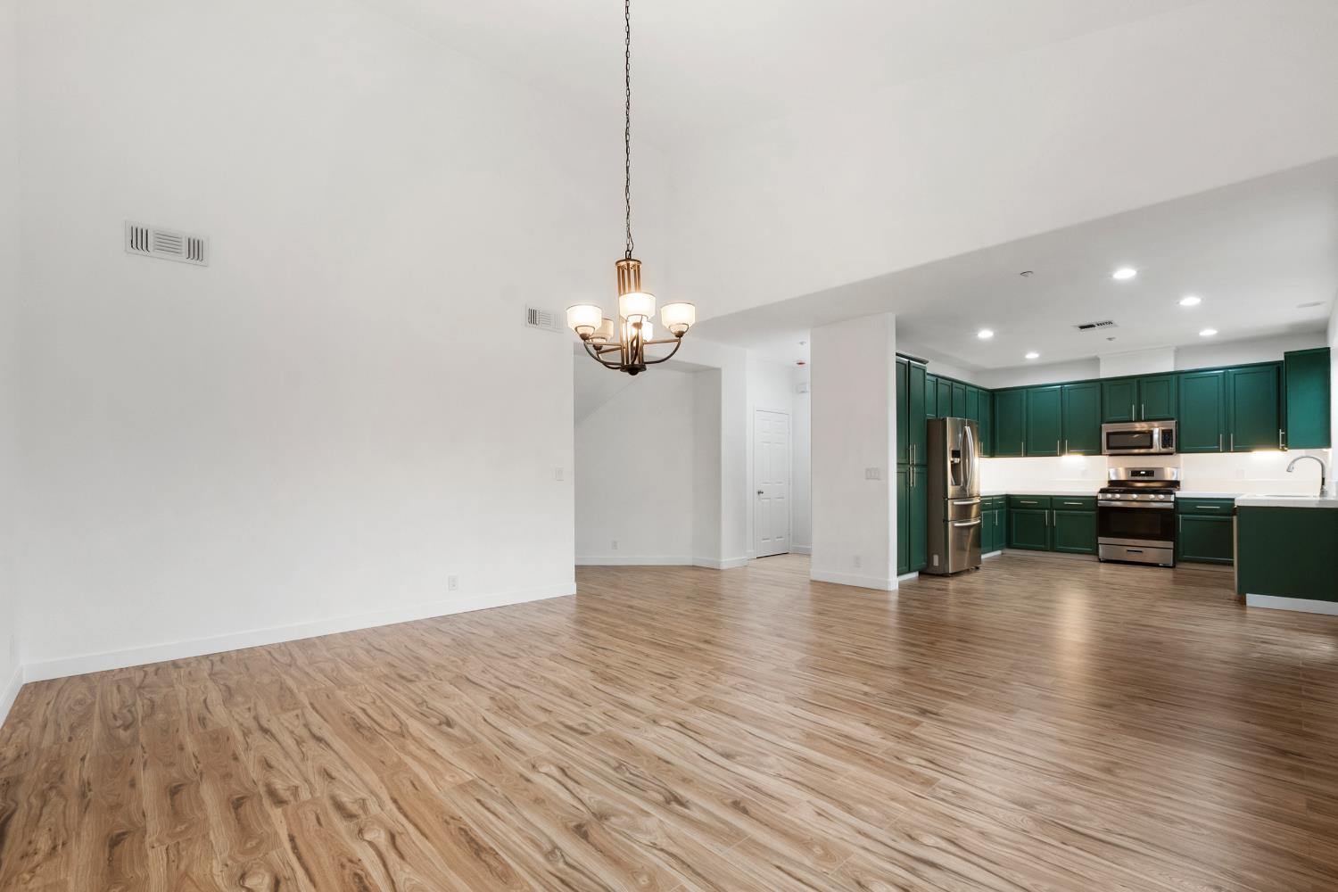 624 Snapdragon Street Winters, CA 95694 - Photo 13 of 65 a view of a livingroom with a kitchen island stainless steel appliances a wooden floor and a chandelier