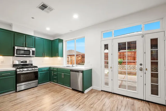 a kitchen with stainless steel appliances granite countertop a sink and wooden cabinets