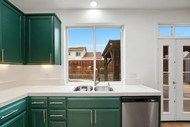 an empty room with wooden floor cabinet and windows