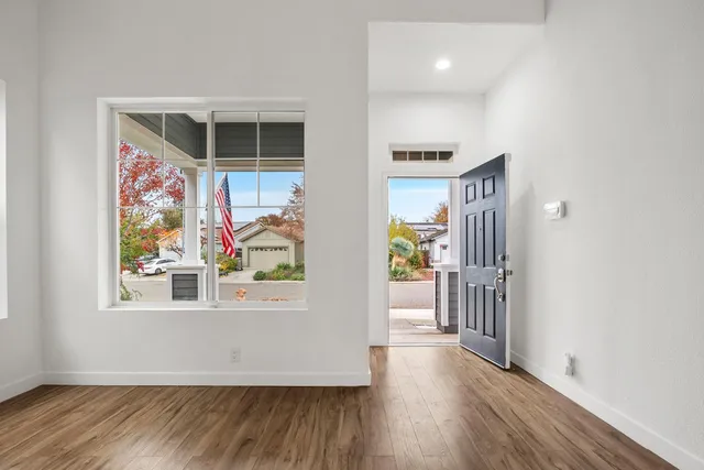 a view of a livingroom with wooden floor and a ceiling fan