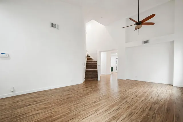 a view of a room with wooden floor a fireplace and a window