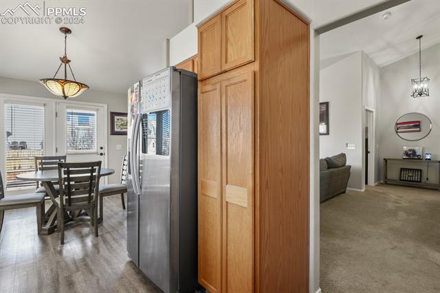 8036 Ferguson Road Peyton, CO 80831 - Photo 10 of 29 Kitchen with a chandelier, dark hardwood / wood-style flooring, stainless steel refrigerator, and decorative light fixtures