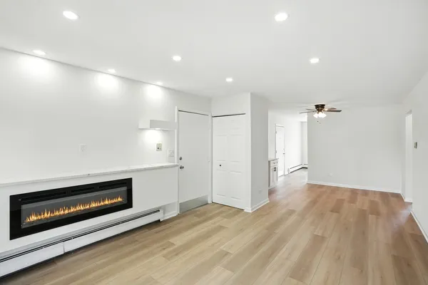 a view of an empty room with a fireplace and a window