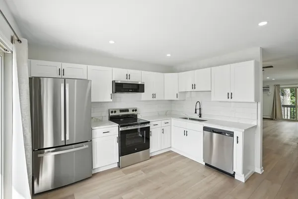 a kitchen with white cabinets and stainless steel appliances