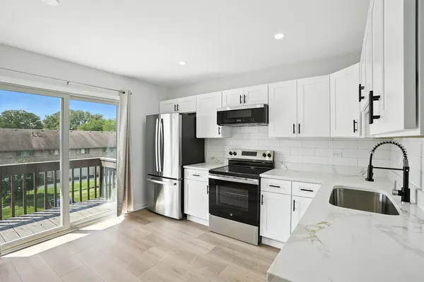 a kitchen with white cabinets and stainless steel appliances