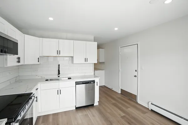 a kitchen with a sink white cabinets and white appliances