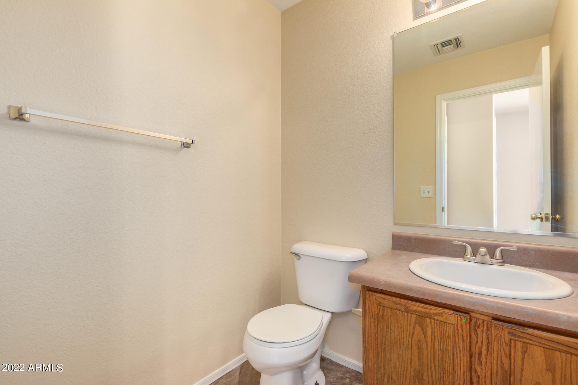 9373 West Eaton Road Phoenix, AZ 85037 - Photo 5 of 19 a bathroom with a sink a toilet and a mirror