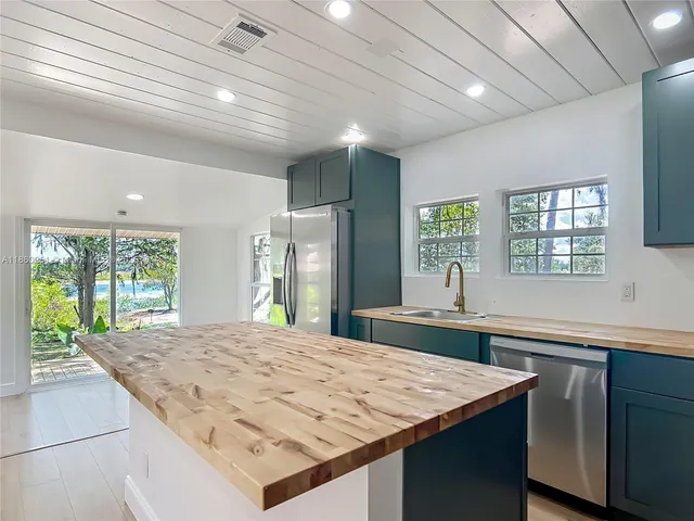 a large kitchen with kitchen island a sink stove and refrigerator