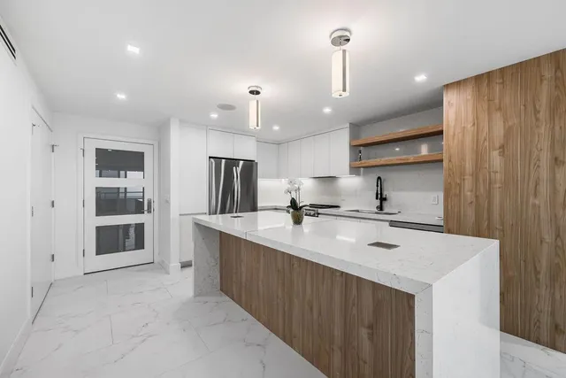 a kitchen with stainless steel appliances a sink stove and refrigerator