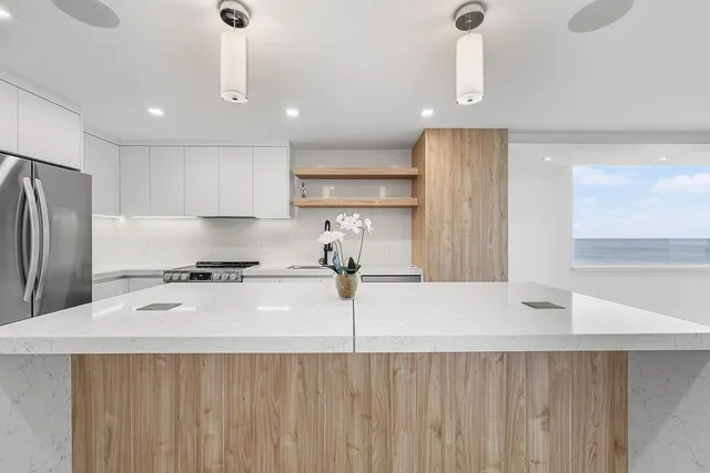 a kitchen with stainless steel appliances sink refrigerator and cabinets