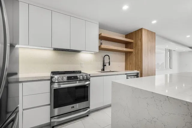 a close view of a sink a faucet and appliances in a kitchen