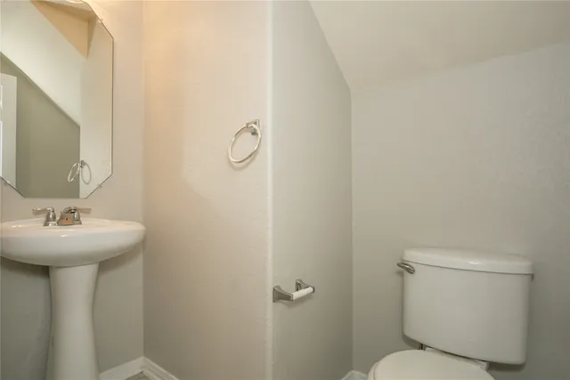 a bathroom with a sink mirror and toilet