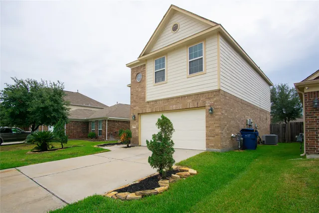 a front view of a house with a garden and plants