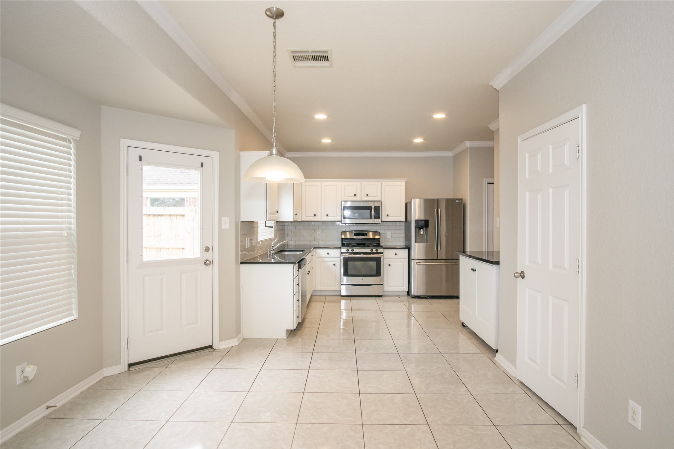 2535 Elm Crossing Trail Spring, TX 77386 - Photo 7 of 33 a kitchen with white cabinets and stainless steel appliances