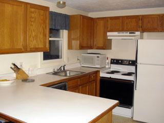 83 Wintergreen Road Mashpee, MA 02649 - Photo 2 of 18 a kitchen with a sink a stove and a refrigerator