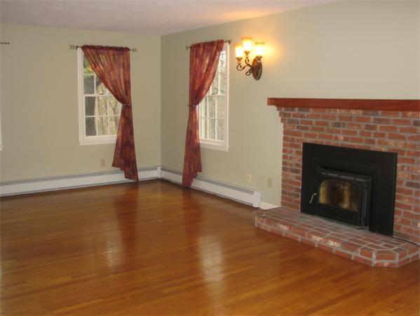 10 Rowley Hill Road Sterling, MA 01564 - Photo 8 of 29 a view of an empty room with wooden floor fireplace and a window
