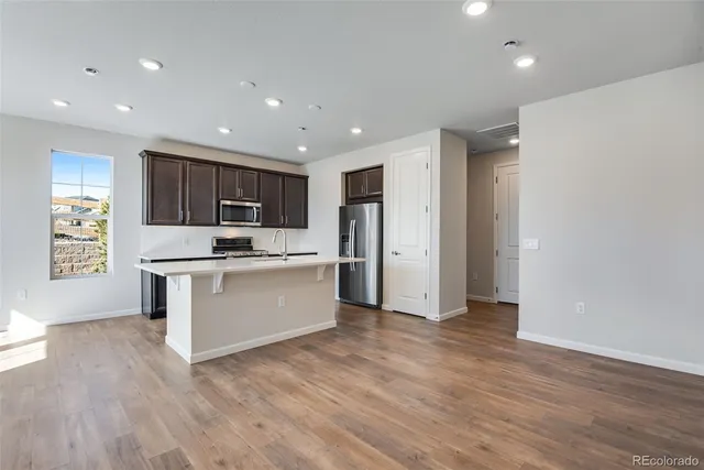 a kitchen with stainless steel appliances granite countertop a refrigerator sink and white cabinets