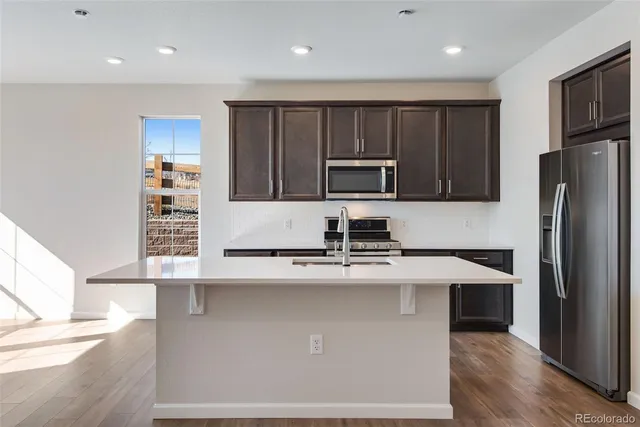 a kitchen with kitchen island a sink stainless steel appliances and cabinets