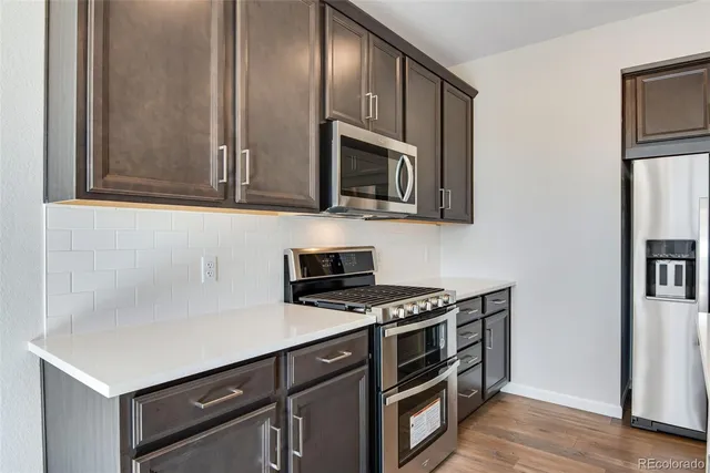 a kitchen with stainless steel appliances a stove microwave and sink