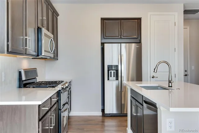 a kitchen with stainless steel appliances granite countertop a sink stove and refrigerator