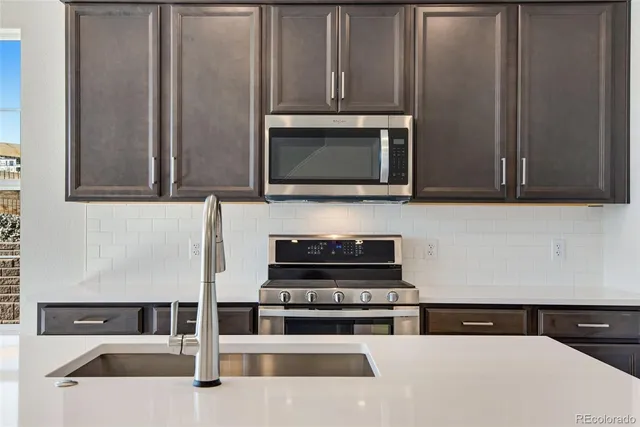 a kitchen with granite countertop a stove and a microwave