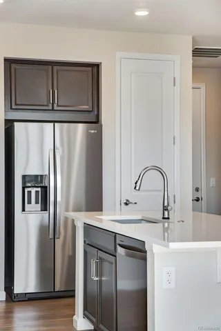 a kitchen with stainless steel appliances granite countertop a refrigerator and a sink
