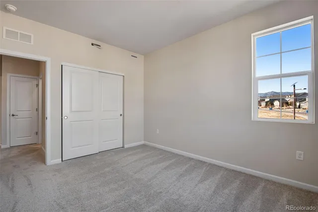 an empty room with windows and cabinet