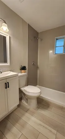 a white toilet sitting next to a bathroom sink