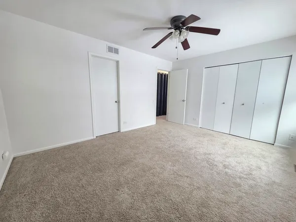 a view of empty room with ceiling fan