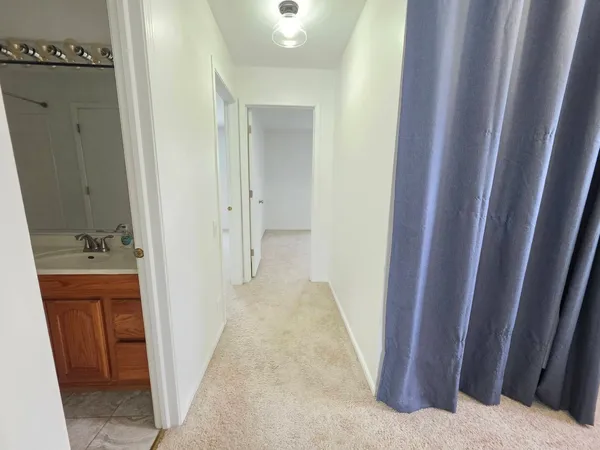 a view of hallway with sink and mirror