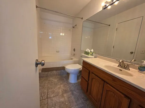 a bathroom with a double vanity sink toilet mirror and shower