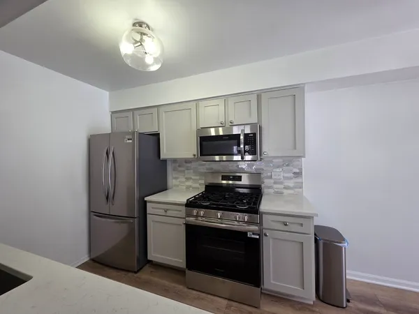 a kitchen with stainless steel appliances a refrigerator stove and microwave