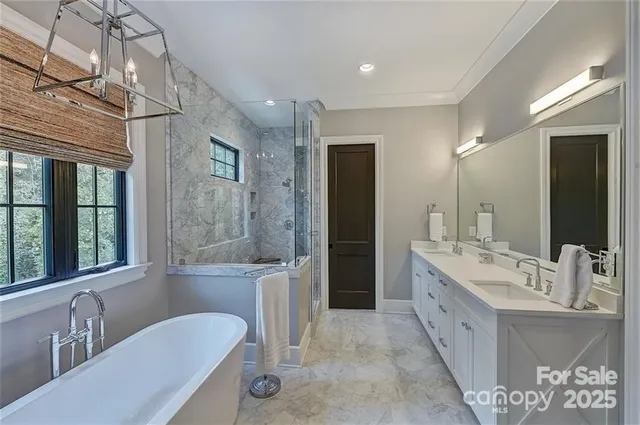 a bathroom with a granite countertop tub sink a two mirror a window and a shower