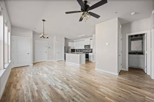 a view of a kitchen with a sink and dishwasher a refrigerator with wooden floor