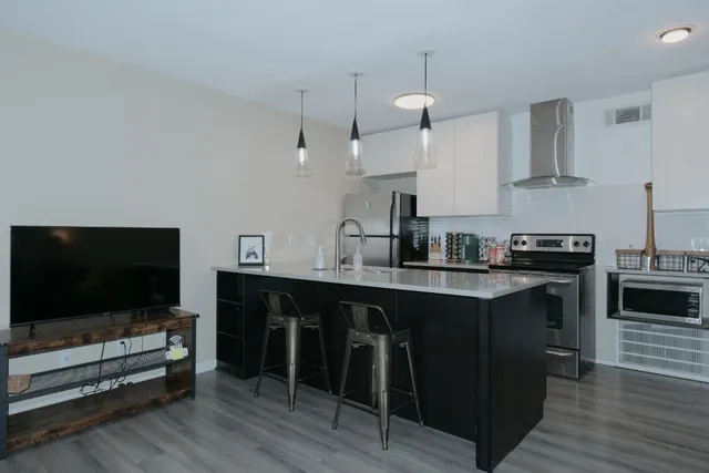 a kitchen with stainless steel appliances a stove a sink and a refrigerator
