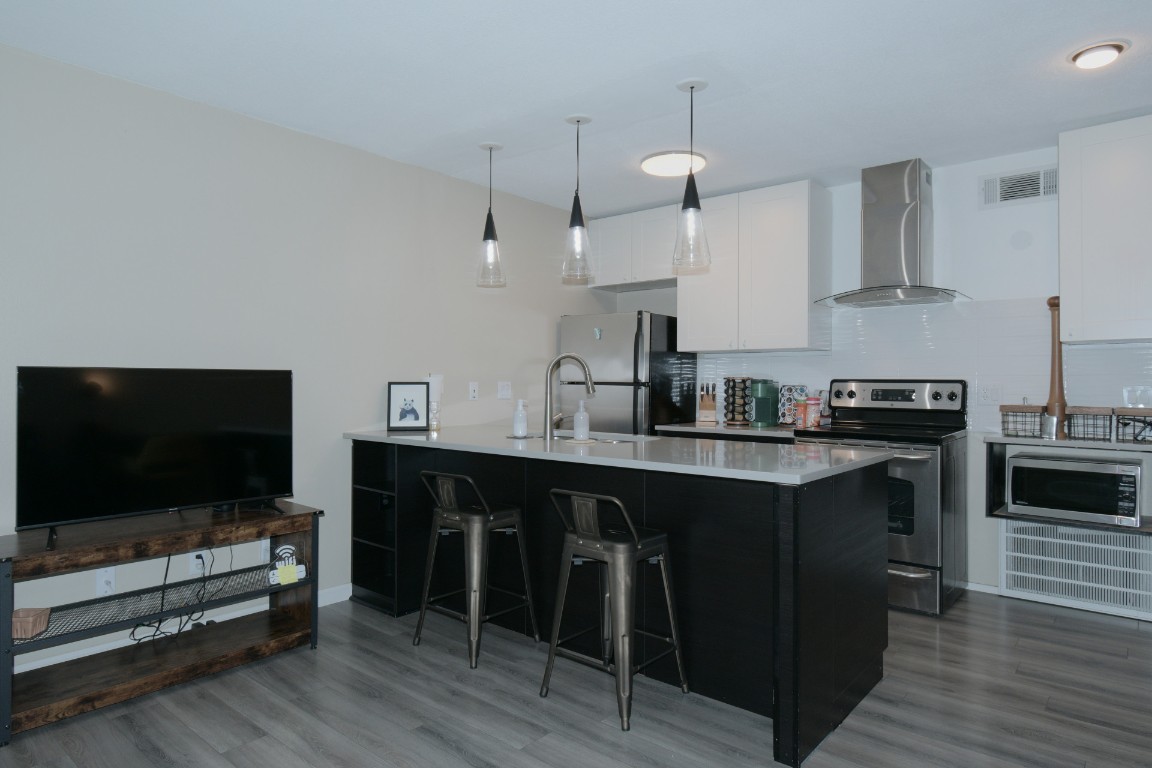 a kitchen with stainless steel appliances a stove a sink and a refrigerator