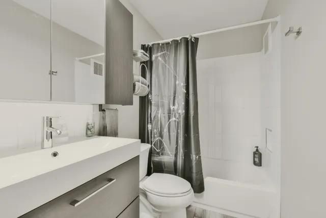 a bathroom with a sink toilet and shower