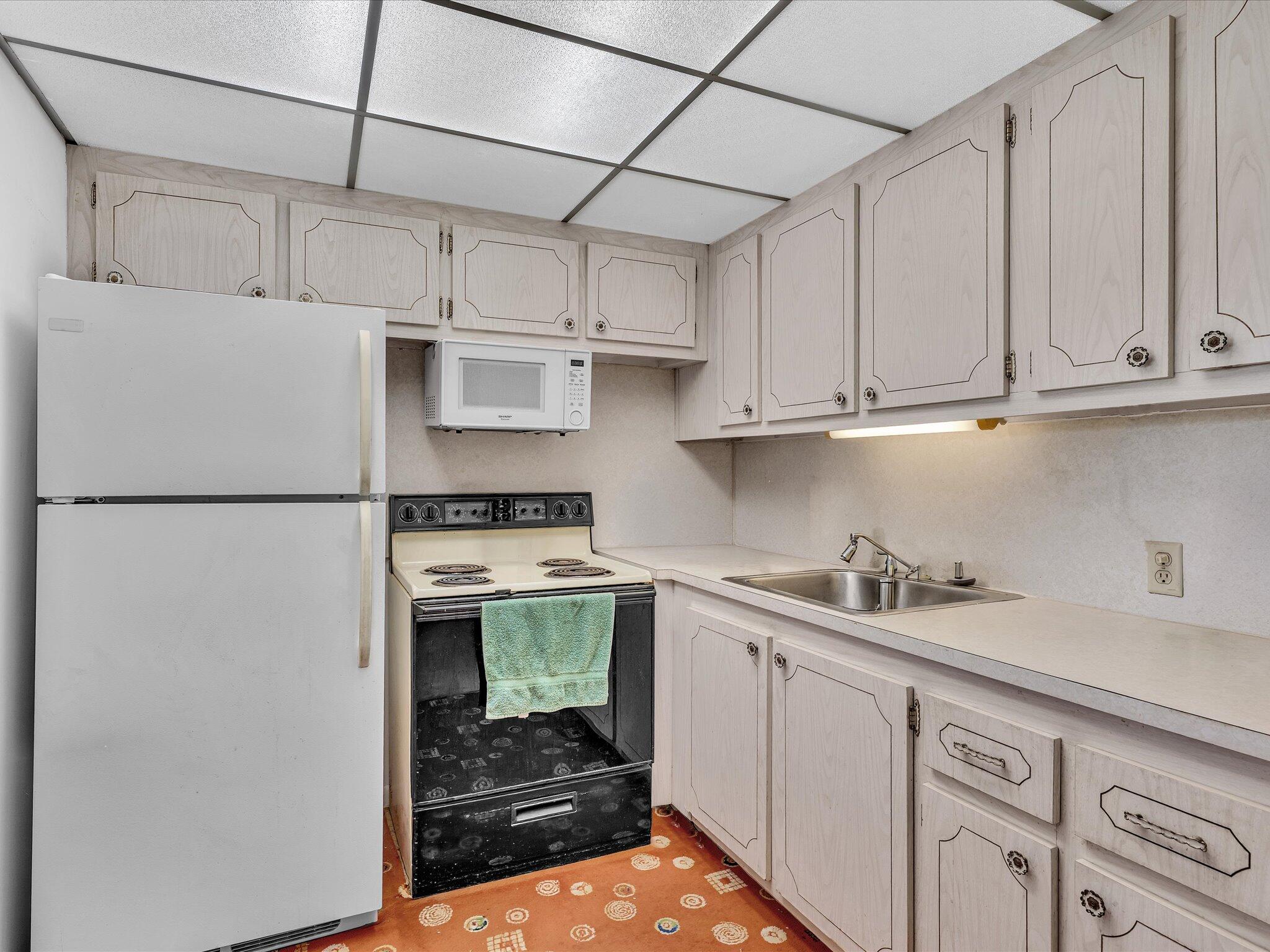289 Fanshaw Drive, Unit G Boca Raton, FL 33434 - Photo 10 of 39 a kitchen with stainless steel appliances granite countertop a sink stove and refrigerator