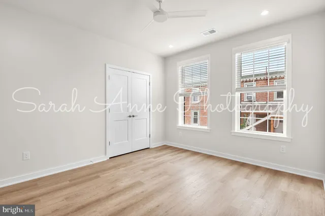 an empty room with wooden floor and windows