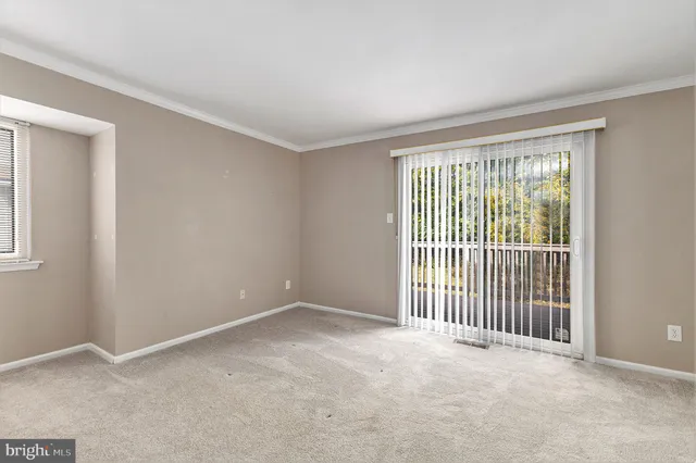 a view of an empty room with closet and entryway