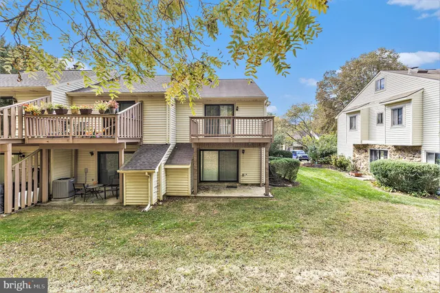 a view of a house with a yard and a large tree