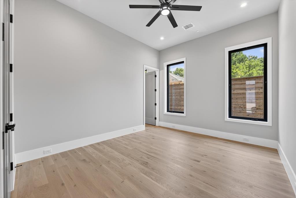11028 Edgemere Road Dallas, TX 75230 - Photo 23 of 40 Bedroom down light wood-finish flooring complements the neutral wall color in this room, featuring a modern black ceiling fan with recessed lighting