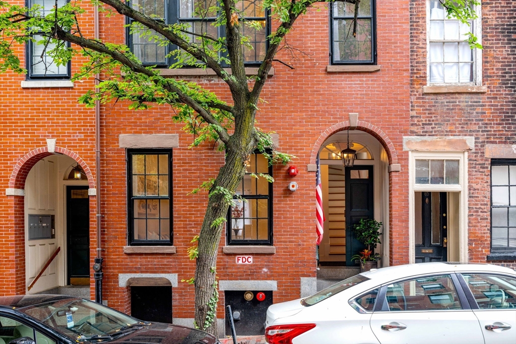 67 Revere Street, Unit 1 Boston, MA 02114 - Photo 1 of 29 a couple of cars parked in front of a brick building